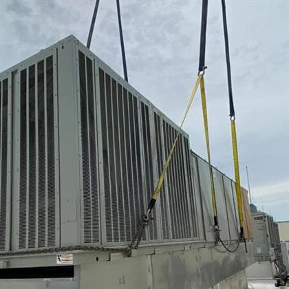 Commercial rooftop HVAC equipment being lifted by crane